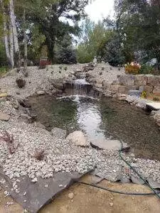 The waterfall, hillside and pond are all rebuilt with new landscape lighting, plantings and groundcover. A 4’ wide waterfall accents the main stream with a smaller waterfall to the side help maintain waterflow. A flagstone patio and boulder walls provide accents to the space.