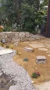 A flagstone patio and boulder walls provide accents to the space.