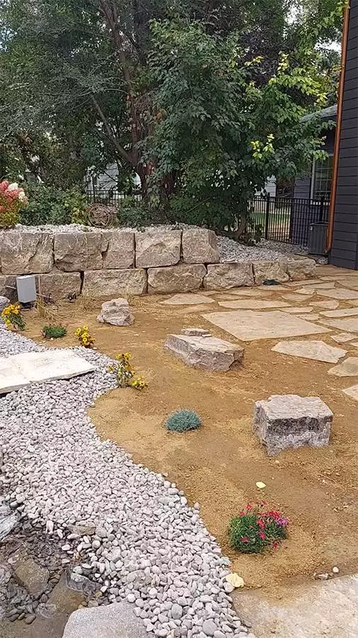 A flagstone patio and boulder walls provide accents to the space.