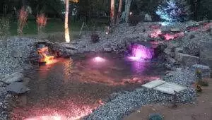 The waterfall, hillside and pond are all rebuilt with new landscape lighting, plantings and groundcover. A 4’ wide waterfall accents the main stream with a smaller waterfall to the side help maintain waterflow.