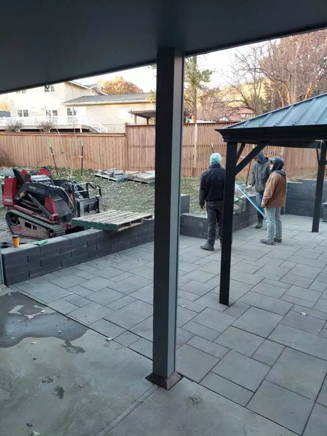 A new courtyard patio with pergola and waterfall highlights this backyard renovation.