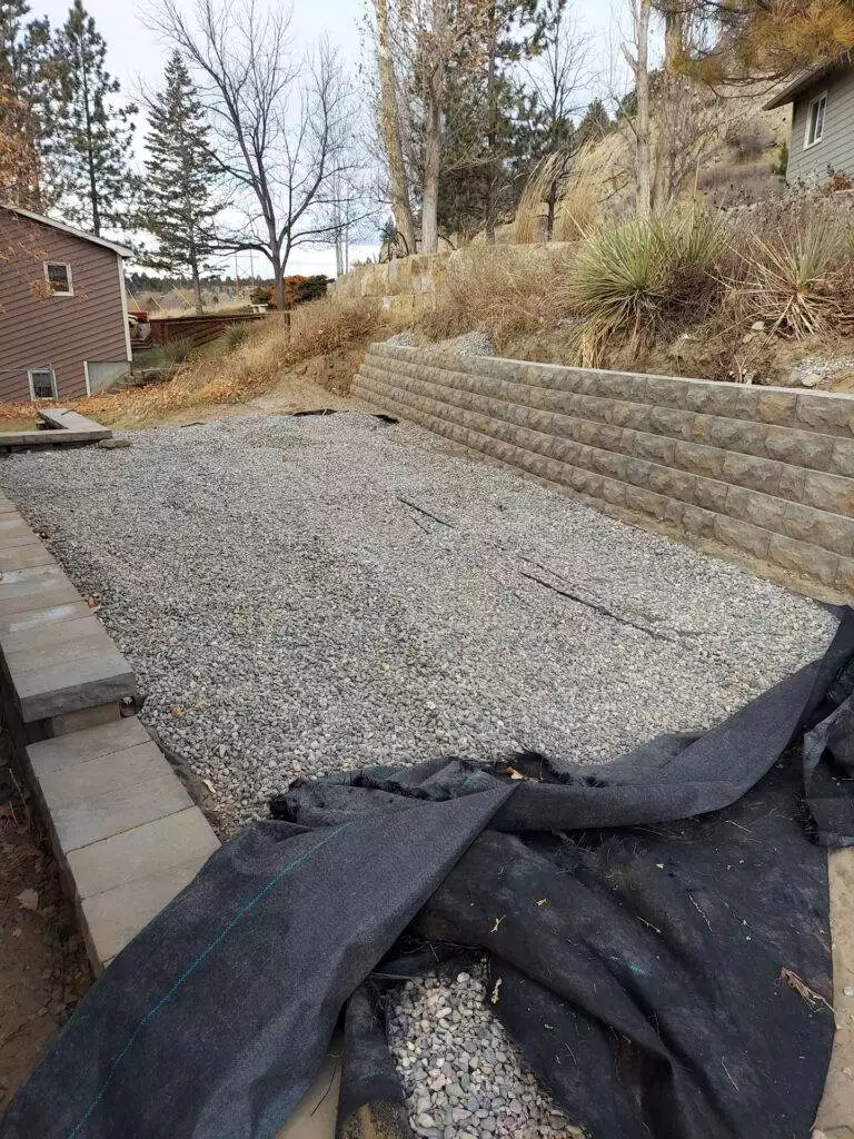 An unusable hillside is transformed with the construction of 2 retaining walls. By building the split walls, CW Desings created a space for a 10x20 shed and parking spot along the driveway.