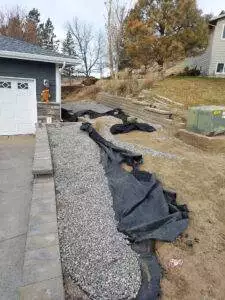 An unusable hillside is transformed with the construction of 2 retaining walls. By building the split walls, CW Desings created a space for a 10x20 shed and parking spot along the driveway. The walls are built using Belgard Belair 2.0 wall block.