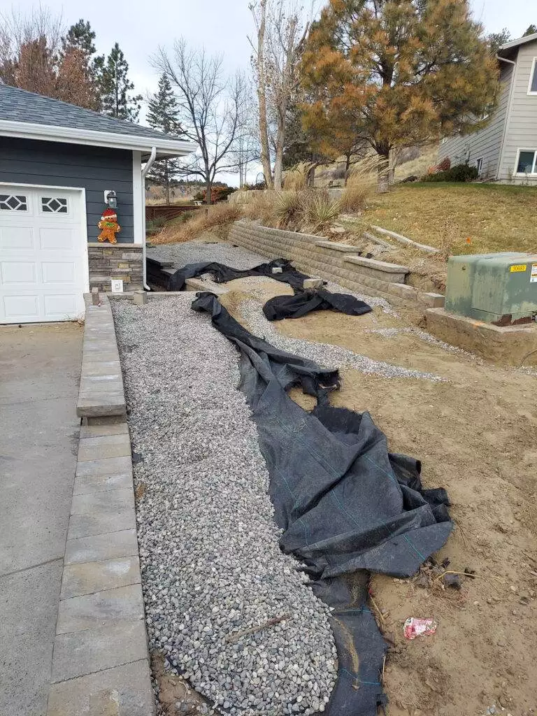 An unusable hillside is transformed with the construction of 2 retaining walls. By building the split walls, CW Desings created a space for a 10x20 shed and parking spot along the driveway. The walls are built using Belgard Belair 2.0 wall block.